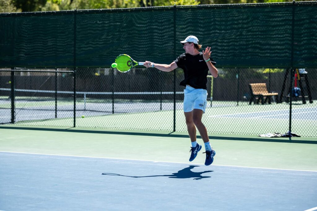 young tennis player jumping shot